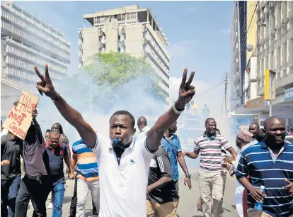  ??  ?? „No Raila, no Kenia“, rufen die jungen Luo-Männer vor brennenden Barrikaden: Wenn die herrschend­en Kikuyu nicht nachgeben, wollen sie das Land in zwei Teile zerreißen.