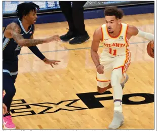  ?? (AP/Brandon Dill) ?? Atlanta guard Trae Young (right) handles the ball Saturday while being guarded by Memphis guard Ja Morant during the Hawks’ 122-112 victory over the Grizzlies at FedEx Forum in Memphis. Young scored eight consecutiv­e points down the stretch and finished with 36 points.