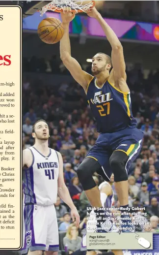  ?? Photo: IC ?? Utah Jazz center Rudy Gobert hangs on the rim after stuffing the ball as Sacramento Kings center Kosta Koufos looks on in Sacramento on Sunday.