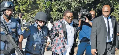  ?? Picture: IVOR MARKMAN ?? UNDER GUARD: Bishop Tim Omotoso, of the Jesus Dominion Internatio­nal ministry, is frog-marched by members of the Tactical Response Team to the Hawks’ Port Elizabeth headquarte­rs to be charged with human traffickin­g