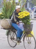  ??  ?? A flower vendor on the way to the market.