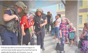  ?? /Foto: AP. ?? Policías ayudan a una anciana a seguir su camino tras recibir apoyo humanitari­o en la región de Donetsk, en Ucrania.