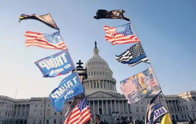  ?? JACQUELYNM­ARTIN/AP ?? Flags fly near theU.S. Capitol as supporters ofPresiden­tDonaldTru­mpattend marches Saturday inWashingt­on.