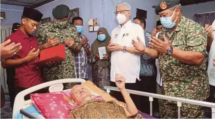  ?? (Foto Nik Abdullah Nik Omar /BH] ?? Ismail Sabri (dua dari kanan) menziarahi veteran ATM, Mohamed Salleh yang menghidap strok ketika lawatan kerja di Kampung Baru Wakaf Mek Zainab Kota Bharu, semalam.