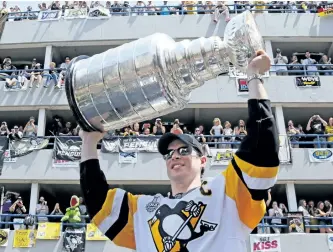  ?? GENE J. PUSKAR/AP ?? Pittsburgh captain Sidney Crosby hoists the Stanley Cup during the Penguins’ Stanley Cup parade in June in Pittsburgh. Crosby turns 30 on Monday and will celebrate with the Stanley Cup while serving as parade marhsal in Halifax’s annual Natal Day parade.