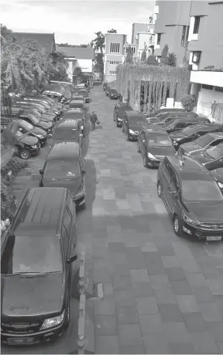  ?? HANUNG HAMBARA/JAWA POS ?? BERHENTI OPERASIONA­L: Halaman belakang balai kota menjadi tempat parkir mobil dinas. Selama cuti Lebaran mobil itu dilarang dipakai.