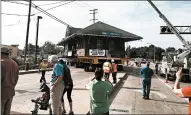  ??  ?? The 118-year-old depot leaves the New Lenox Metra station as ComEd crews lift the electrical lines.