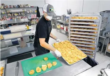  ?? CARLINE JEAN/SOUTH FLORIDA SUN SENTINEL PHOTOS ?? Farm to Fork Meals chef-owner Michael Panza prepares chicken for grab-and-go meals in downtown Fort Lauderdale.