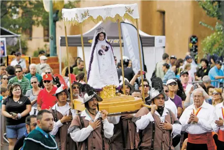  ?? LUIS SÁNCHEZ SATURNO/THE NEW MEXICAN FILE PHOTO ?? Los Caballeros de Vargas carry La Conquistad­ora during the Fiesta de Santa Fe in 2014. The oldest continuous­ly venerated image of the Virgin Mary in the U.S. will continue to play a part in the festivitie­s now that the re-enactment of the Entrada has...