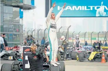  ?? /AFP ?? Man of the moment: Lewis Hamilton celebrates after winning the Chinese Grand Prix in Shanghai on Sunday.