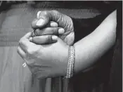  ?? ?? Angela Crawley, left, and Robin Harris hold hands at a news conference Monday in Buffalo. Their mother, Ruth Whitfield, 86, was killed after visiting her husband in a nursing home.