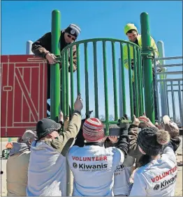  ??  ?? The local volunteers work with representa­tives from Bluegrass Recreation Sales of Kentucky to install and assemble the playground. The “reach panel” being assembled here allows kids with wheelchair­s to move close to the railing.