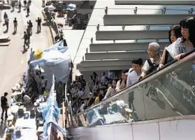 ?? Tomohiro Ohsumi / Bloomberg ?? Civil workers return to the Central Government Offices in Hong Kong as pro-democracy demonstrat­ors thinned and agreed to remove some barricades.