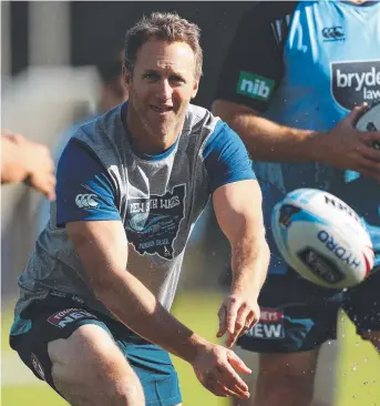  ?? Picture: BRETT COSTELLO ?? TEST: Mark Gasnier passes wet balls from a tub at training yesterday.