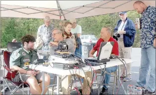  ?? Keith Bryant/The Weekly Vista ?? Scout Trey Park, left, sits and talks with fellow scout Michael Pitts, radio club technical officer Steve Werner and club member Frank Majdan. Repeater trustee Fred Lemley sits in the background, to the left, along with radio club treasurer Marc...