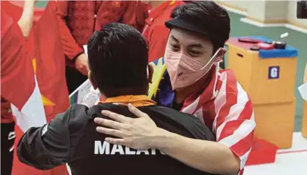  ?? ?? Johnathan Wong celebrates winning gold in the 10m air pistol with his coach at the Hanoi National Training Centre yesterday.