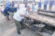  ??  ?? Raphael Cosme documenta el hallazgo de un buque colonial en una playa de San Agustín.