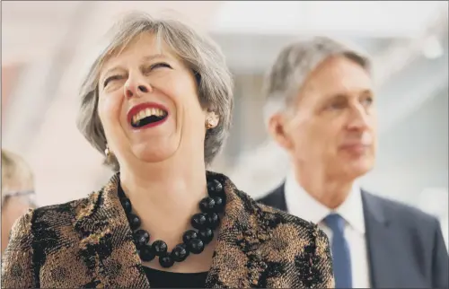  ?? PICTURE: ANDREW YATES/PA WIRE. ?? LAUGHING MATTER: Prime Minister Theresa May and Chancellor Philip Hammond visit an engineerin­g training facility in the West Midlands yesterday.