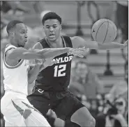  ?? Associated Press ?? Looking for a teammate: Texas guard Courtney Ramey (3) passes the ball past Baylor guard Jared Butler (12) during the first half on an NCAA college basketball game Wednesday in Austin, Texas.