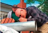  ??  ?? MADRAS, Oregon: This frame grab from a video shows Gene Brick, 92, left, and his son, Bartt Brick, peering through a telescope that they made together in 1964. — AP