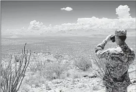  ?? Arkansas Democrat-Gazette file photo ?? Spc. Ben Sliger scans the desolate New Mexico landscape as he searches for undocument­ed immigrants during a deployment of the Arkansas National Guard to the Mexico border area in 2006.