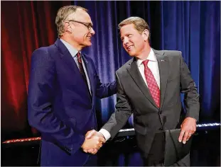  ?? CURTIS COMPTON / CCOMPTON@AJC.COM ?? Lt. Gov. Casey Cagle and Secretary of State Brian Kemp, the two remaining Republican­s in the race for Georgia governor, shake hands at the conclusion of their Atlanta Press Club debate at the Georgia Public Broadcasti­ng studios on Thursday in Atlanta.