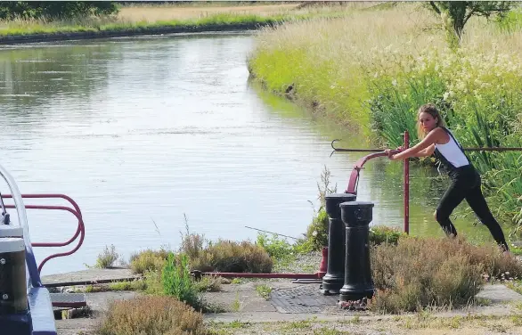  ?? PHOTOS: MIKE GRENBY ?? A lock operator on the Burgundy Canal in France opens the locks to allow the luxurious hotel barge La Belle Epoque to descend to the next canal.