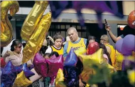  ?? Christina House Los Angeles Times ?? FANS gather at a makeshift memorial for Kobe Bryant this month at L.A. Live.