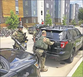  ?? [MICHELLE CHARLES/STILLWATER NEWS PRESS] ?? Tactical officers return from Prime Place Apartments in Stillwater on Sunday, preparing to leave the scene, after doing a search following a possible threat.