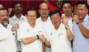  ??  ?? In soldarity: Lim (second from left) shaking hands with Chow as other elected representa­tives cheer them on at Komtar in Penang.