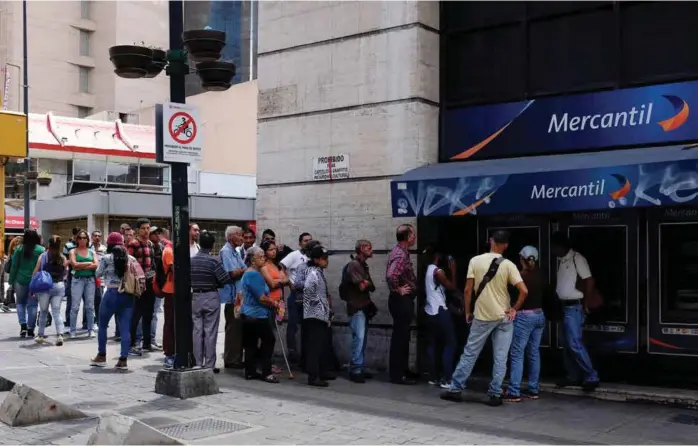  ??  ?? KONTANTRUS­H: Venezuelan­ere i Caracas sto i lange køer foran pengeautom­atene før helgen for å ta ut kontanter. Landet innførte fra mandag nye pengesedle­r som har fem nuller faerre enn de gamle.