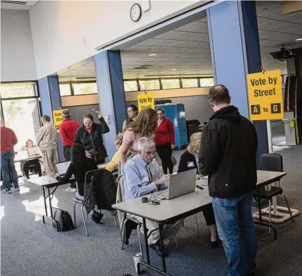  ?? Jarrett Liotta/Contribute­d photo ?? Election officials help the first wave of voters during voting for the Wilton Town Meeting in May at Wilton High School.