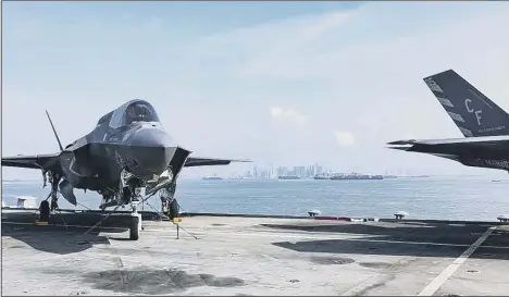  ?? Picture: Royal Navy ?? STEP FORWARD Singapore pictured in the background from the flight deck of HMS Queen Elizabeth.