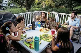  ??  ?? Half-siblings from the same donor father eat dinner together on July 12 in Boston.