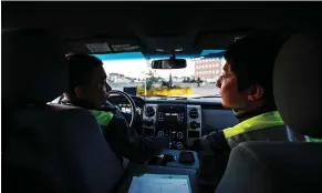  ??  ?? Sazzad Hossain, left, and Jimmy Jeong drive around Olds, Alta., as part of a citizens’ patrol that keeps an eye out for signs of crime or suspicious activities.