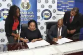  ?? ?? Velma Ricketts Walker (centre-left), CEO/ Commission­er, JCA, and Selvin Hay, Chief Technical Director, FID, sign a Memorandum of Understand­ing on June 7, 2022, formalisin­g the strategic partnershi­p between both organisati­ons. Looking on are Dalila Jones-kerr, Public Relations, JCA, and Courtney Smith, Legal Director, FID.