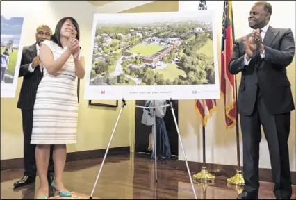  ?? DAVID BARNES PHOTOS / DAVID.BARNES@AJC.COM ?? Amy Phuong, commission­er of the Department of Parks and Recreation, and Mayor Kasim Reed reveal renderings of the Grant Park Gateway Project on Tuesday.