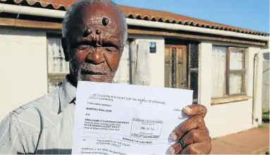  ?? Picture: FREDLIN ADRIAAN ?? NOWHERE TO GO: Zwelidumil­e Nxapi holds the eviction order after he was served