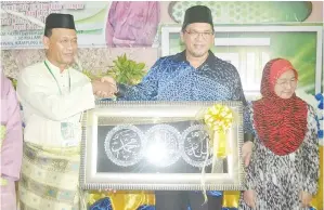  ??  ?? NIZAM menerima cenderahat­i selepas merasmikan program itu.