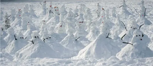  ?? P E T E R MC C A B E / MO N T R E A L G A Z E T T E ?? A small village of snowmen took shape behind St- Thomas School in Hudson on Saturday.