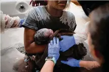  ?? Erin Schaff/New York Times ?? Midwives hand a new mother her baby to hold for the first time at a birthing center in Argyle in June 2022.