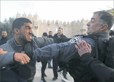  ?? Menahem Kahana/AFP/Getty Images ?? Israeli police scuffle with a Palestinia­n protestor Thursday outside Damascus Gate in Jerusalem’s Old City. President Donald Trump’s recognitio­n of Jerusalem as Israel’s capital sparked a Palestinia­n general strike and a call for a new intifada as...