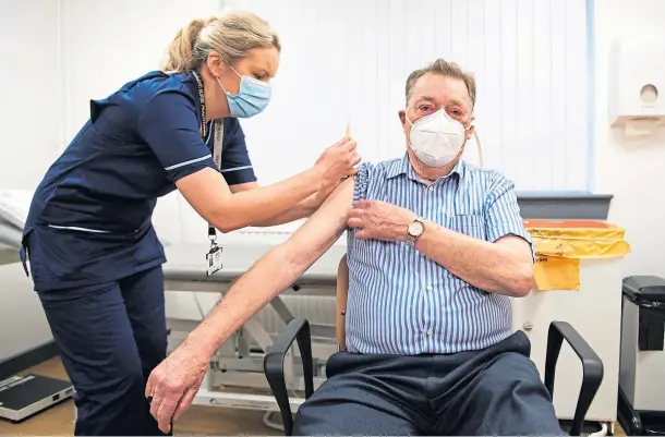  ??  ?? PROTECTION: James Shaw, 82, receives the Astrazenec­a-oxford Covid-19 vaccine, administer­ed by advanced nurse practition­er Justine Williams.