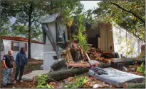  ?? CHRISTINA MATACOTTA/ATLANTA JOURNAL-CONSTITUTI­ON ?? James Duffy, left, and William Holden and look at the damage to a trailer where a man was killed by a fallen tree early Thursday morning at East Gate Mobile Home Park in Acworth, Ga. According to Alicia Martinez, granddaugh­ter of the trailer’s owner, the victim had been renting a room from her grandmothe­r for only a few weeks. Strong gusts from Hurricane Zeta caused the fatal tree fall.