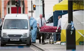  ??  ?? Crime scene: City morgue officers removing the body of a woman at russell square in central London. — AFP