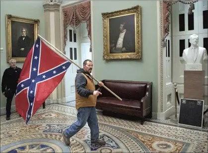  ?? Saul Loeb AFP/Getty Images ?? THE CONFEDERAC­Y was defeated 156 years ago, but its f lag was paraded through the halls of the besieged U.S. Capitol.
