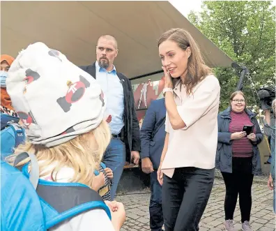  ?? AFP ?? Marin habla con niños tras una reunión de su partido