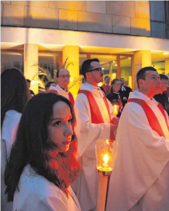  ?? FOTOS: MICHAEL HESCHELER ?? Dreiklang: Lichter, Musik und Worte erzeugen beim Implus des evangelisc­hen Pfarrers Micha Fingerle vor dem Rathaus eine außergewöh­nliche Stimmung.