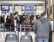  ?? RICARDO B. BRAZZIEL TNS ?? Travelers wait in line to pass through a security checkpoint at Austin-Bergstrom Internatio­nal Airport .