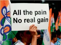  ?? AFP ?? A supporter of West Bengal chief minister Mamata Banerjee holds a placard as she delivers a speech during a protest against demonetisa­tion in New Delhi on Wednesday. —